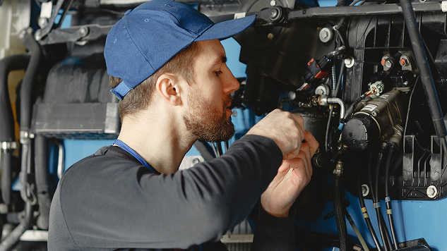 Mechanic working on a vehicle engine in the shop